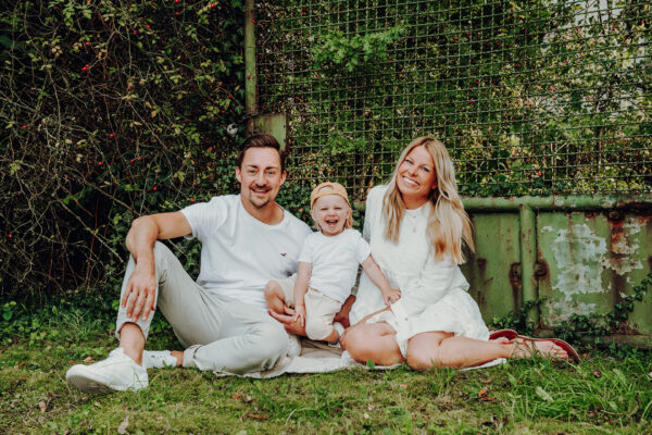 Fröhliche Familie, die im Freien sitzt, beim Family & Friends Fotoshooting im Fotostudio Sabrina Zeuge in Unna.